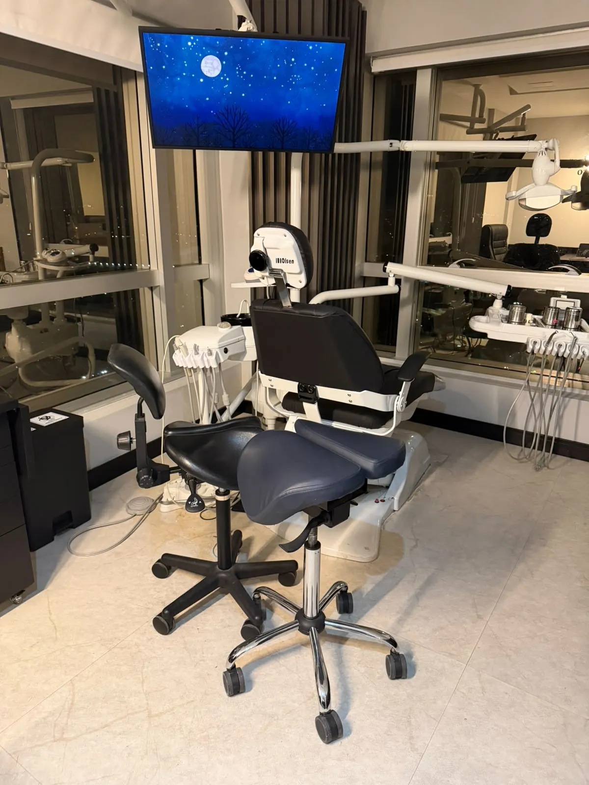 Consultório da Eleve, com cadeira odontológica e vista da cidade à noite
